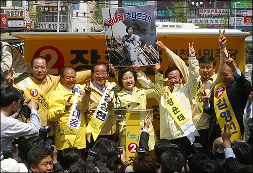 추 선대위원장이 광주공원에서 광주지역 후보자들과 함께 민주당을 지지해줄 것을 호소하고 있다. 한편 한 시민이 직접 제작한 포스터를 추 의원에게 선물하기도 했다. 